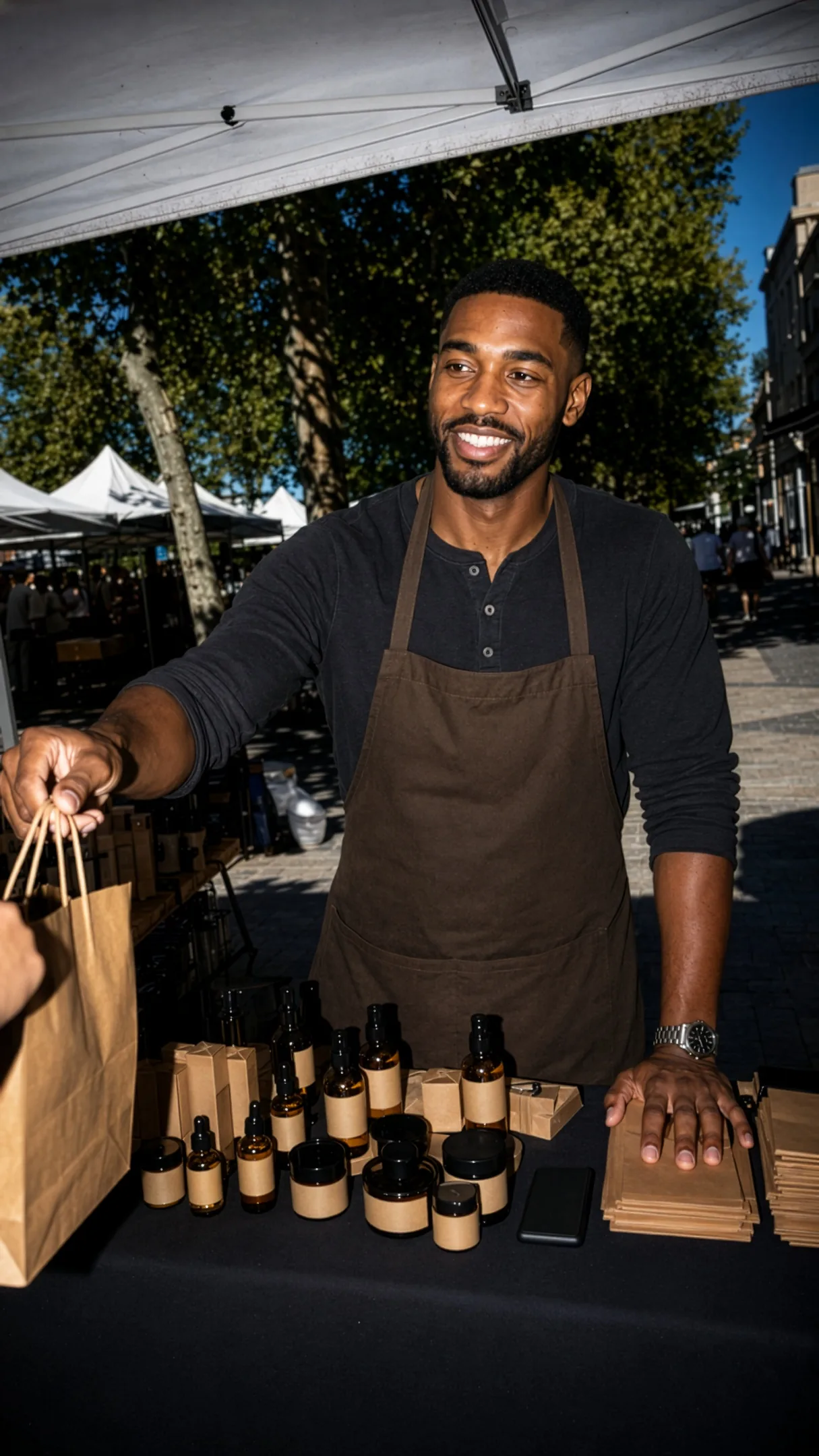 A founder grinning at a market stall in full daylight, flash-lit against a darker street.